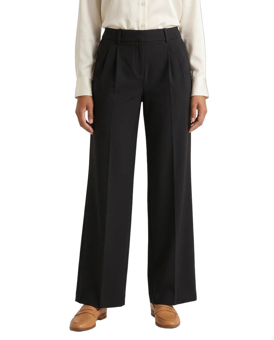 Person wearing a white shirt and Calvin Klein black wide-leg pants on a white background