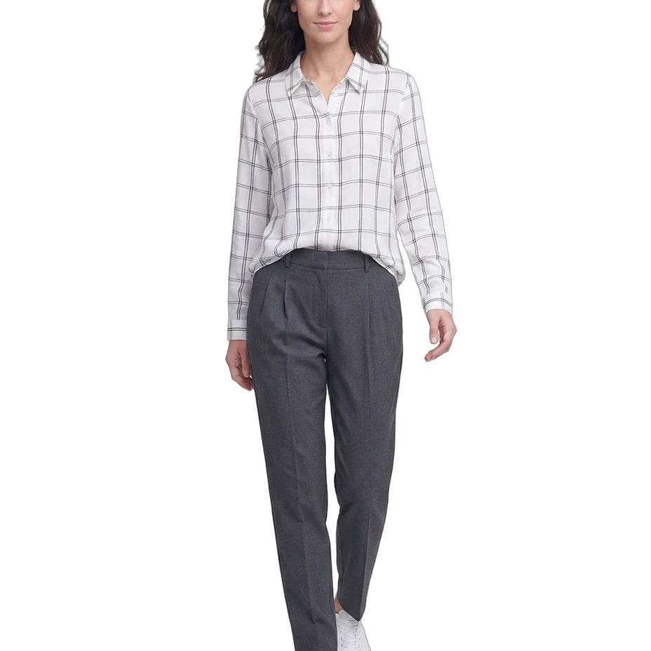 Woman wearing a checkered Calvin Klein shirt and gray pants on a white background