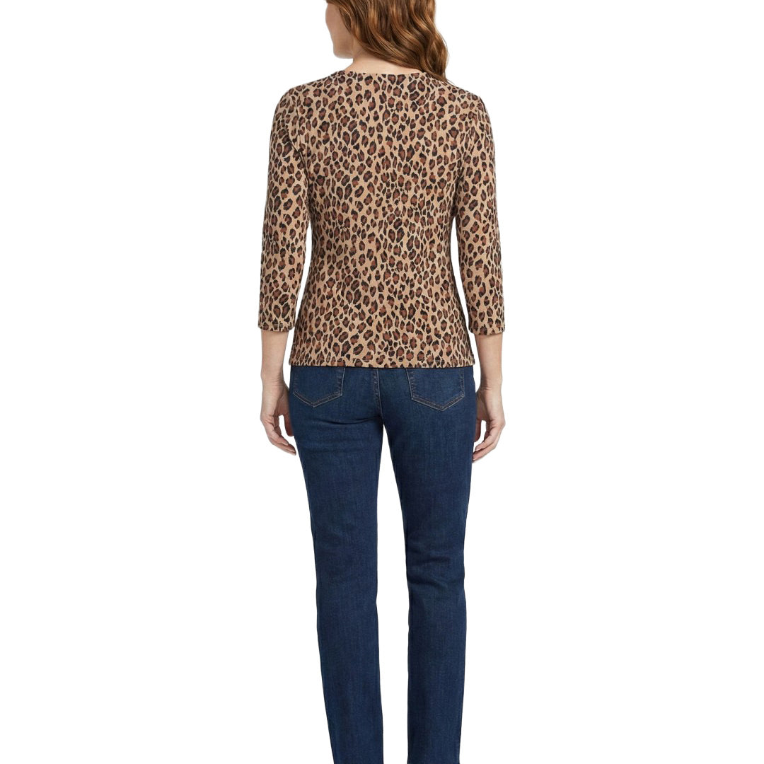 Woman wearing a leopard print top and blue jeans on a white background