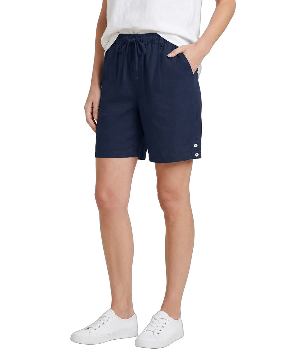Person wearing navy shorts with white buttons on a white background