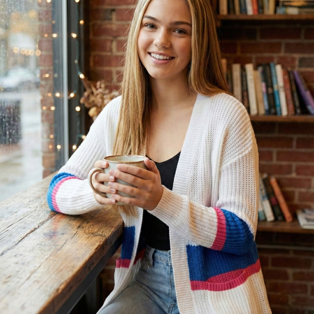 Woman holding a mug in a cozy indoor setting with books and decor.