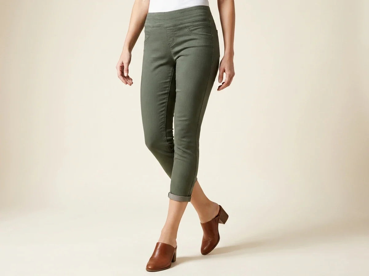 Cropped view of a woman wearing olive green stretch pull-on capri pants with cuffed hems and cognac brown leather block-heel mules.
