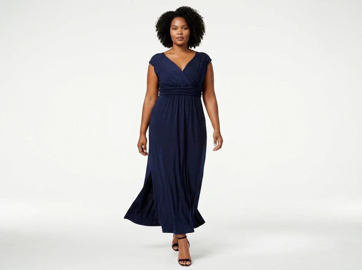A woman modeling a navy blue maxi dress with a V-neckline, cap sleeves, and a gathered waist, photographed against a clean white studio background.