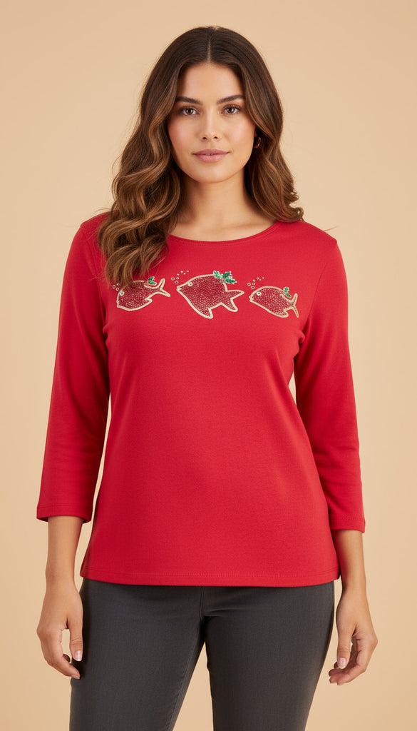 Woman wearing a red long-sleeve shirt with fish designs on a beige background
