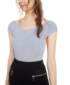 Woman wearing a fitted gray top and black pants on a white background