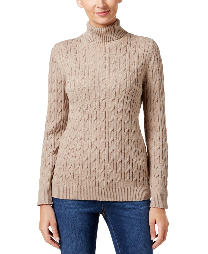 Beige cable knit turtleneck sweater worn by a person on a white background