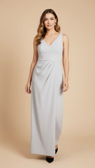 Woman wearing a light blue sleeveless gown against a beige background