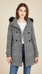 Teen wearing a checkered coat with fur-lined hood on a beige background
