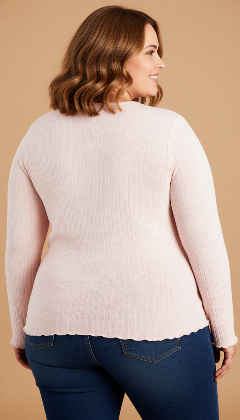 Woman wearing a light pink sweater and blue jeans on a beige background