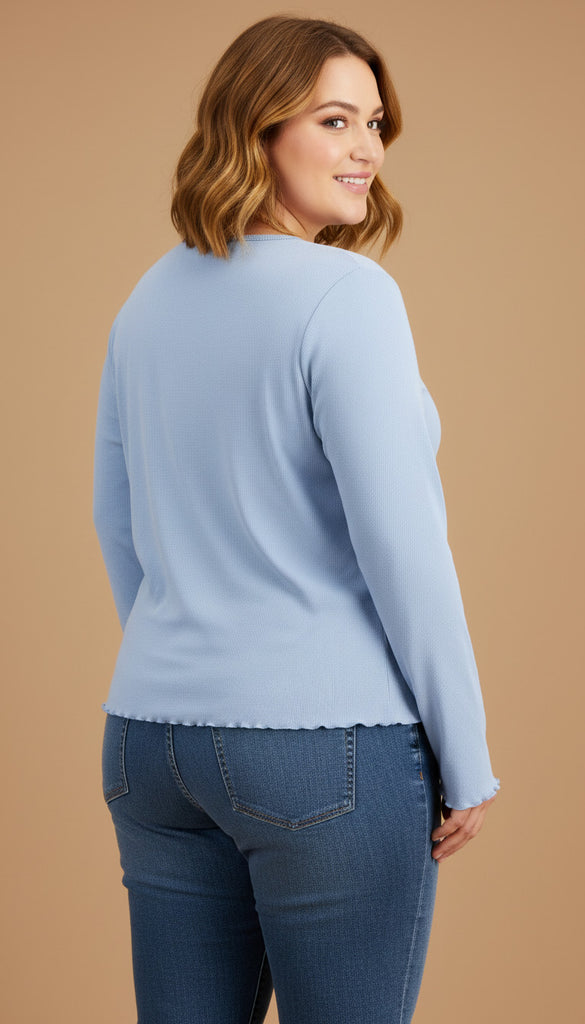 Woman wearing a light blue sweater and jeans on a beige background