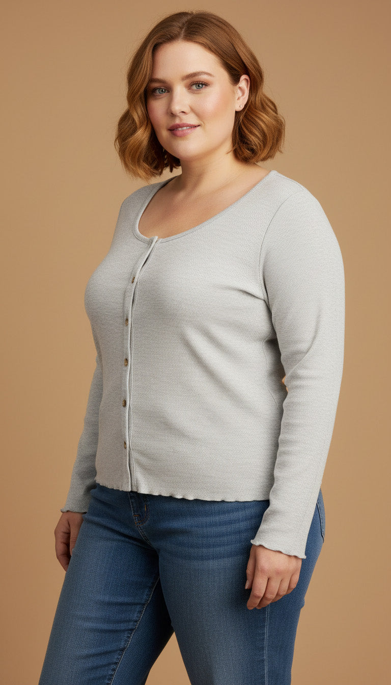 Woman wearing a light gray cardigan and blue jeans on a beige background