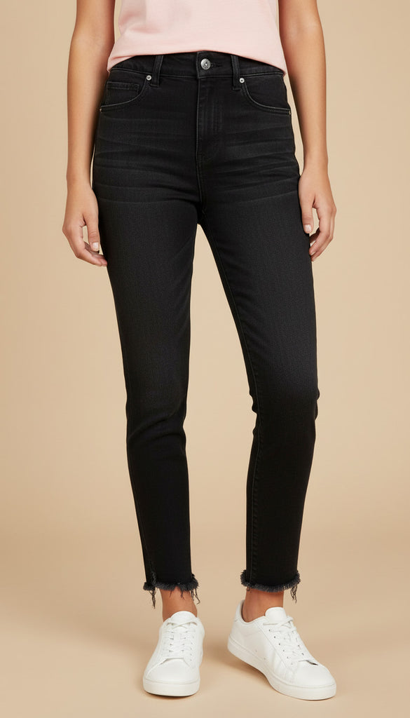 Person wearing black jeans and white sneakers on a beige background