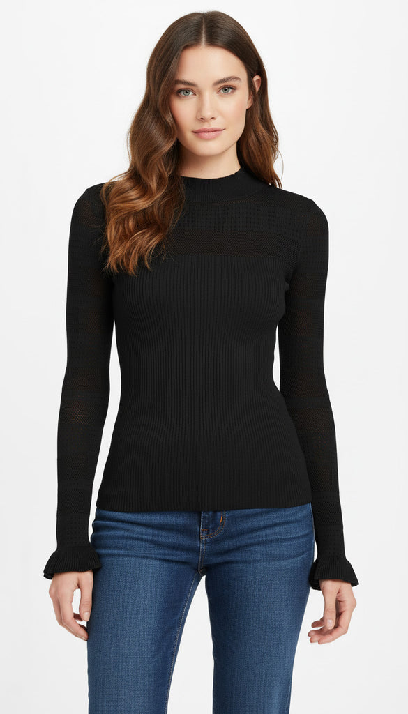 Woman wearing a black ribbed long-sleeve top and blue jeans on a white background