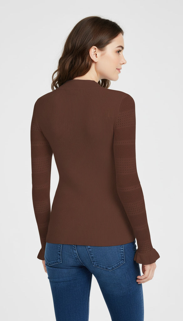 Woman wearing a brown long-sleeve top and blue jeans on a white background