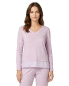 Woman wearing a light purple long-sleeve top and pants on a white background