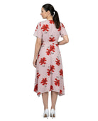 Woman wearing a pink dress with red floral pattern on a white background