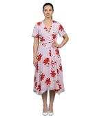 Woman wearing a pink dress with red floral pattern on a white background