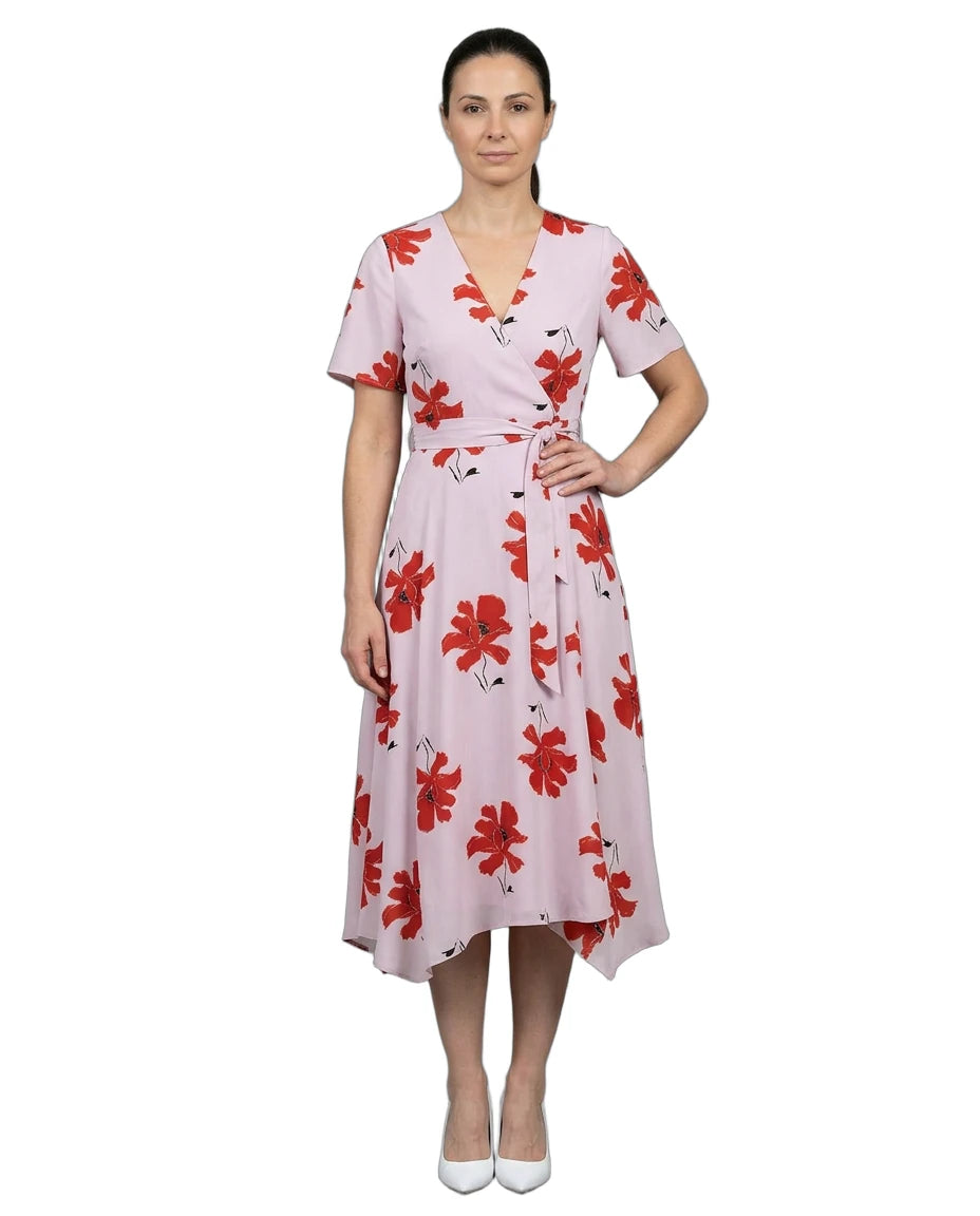 Woman wearing a pink dress with red floral pattern on a white background