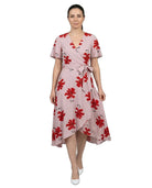 Woman wearing a pink dress with red floral pattern on a white background