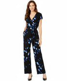 Woman wearing a black jumpsuit with blue butterfly pattern on a white background