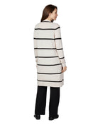 Woman wearing a long, striped sweater dress on a white background