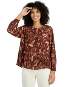 Woman wearing a brown patterned blouse on a white background