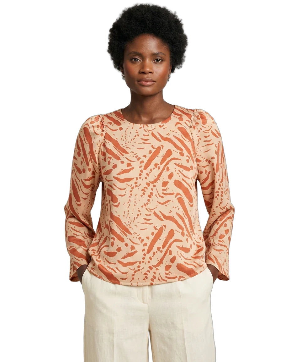 Woman wearing a patterned long-sleeve top on a white background