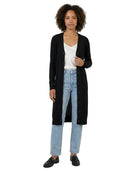 Woman wearing a black cardigan, white shirt, and blue jeans on a white background