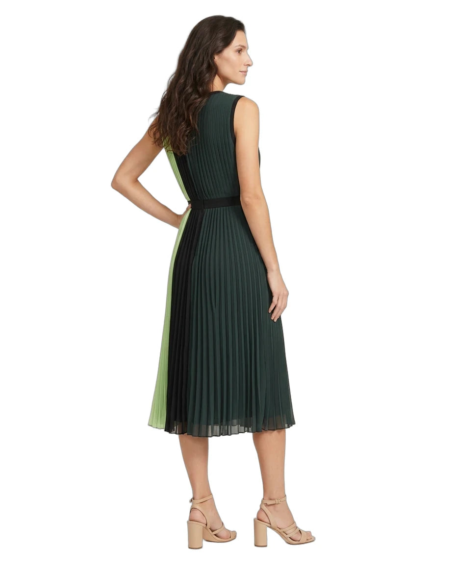 A woman modeling a sleeveless pleated midi dress from the back, featuring a dark green body with a light green side panel and a black waistband, paired with beige heeled sandals against a white background.