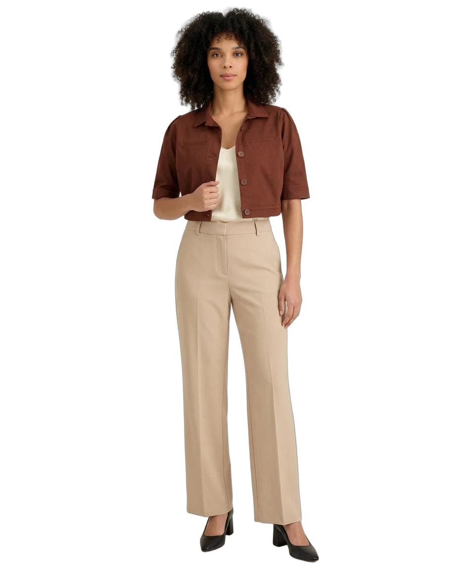 A woman modeling a brown short-sleeve cropped button-up shirt, beige wide-leg trousers, a cream top, and black heels against a plain white background.