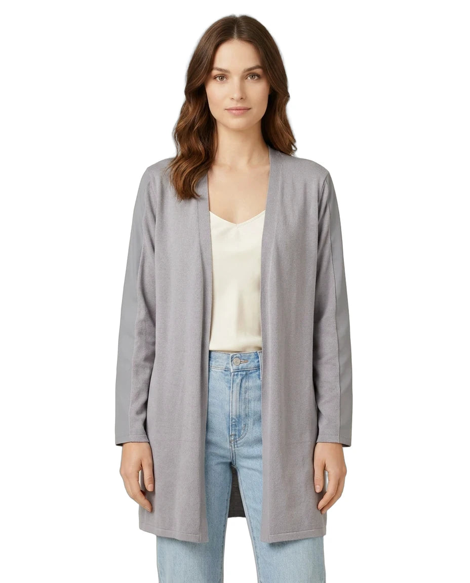 Woman wearing a gray cardigan over a white top and blue jeans on a white background