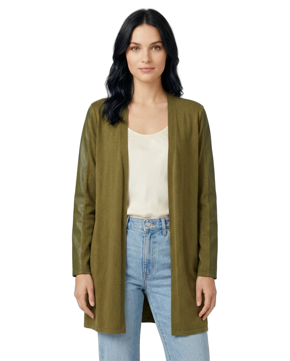 Woman wearing an olive green cardigan over a white shirt and blue jeans on a white background