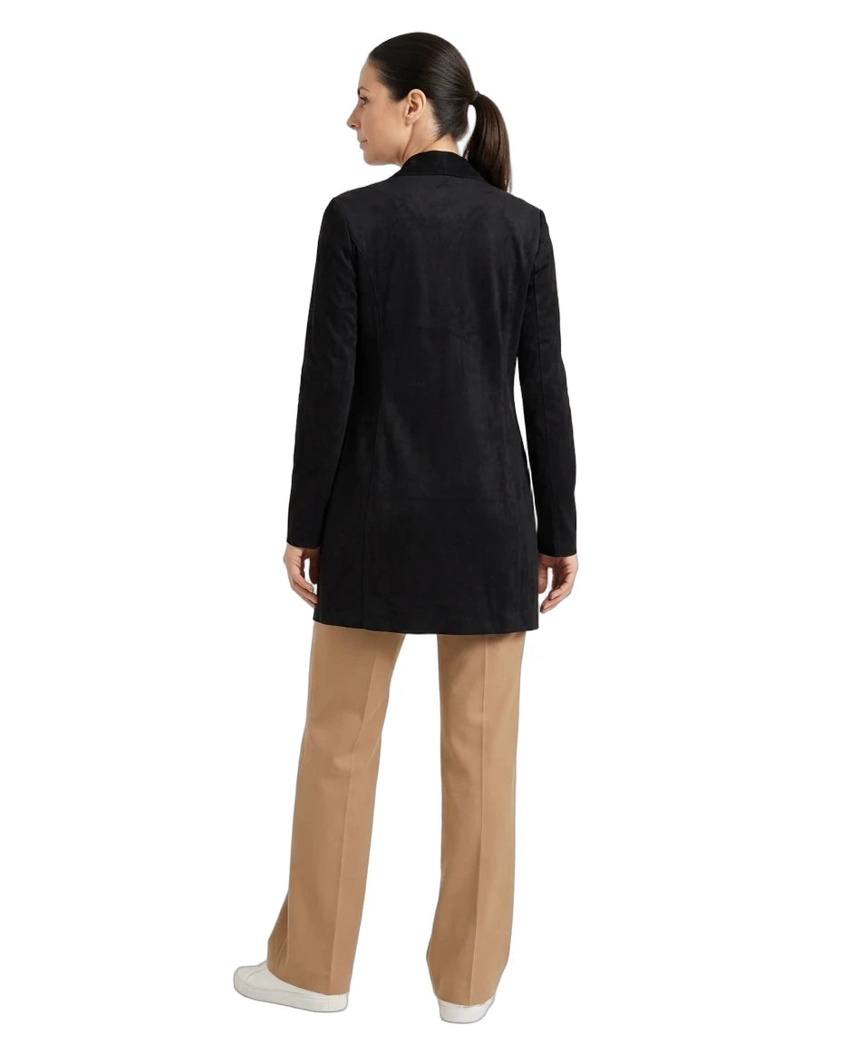 A woman shown from the back wearing a black longline blazer, tan wide-leg trousers, and white sneakers against a plain white background.