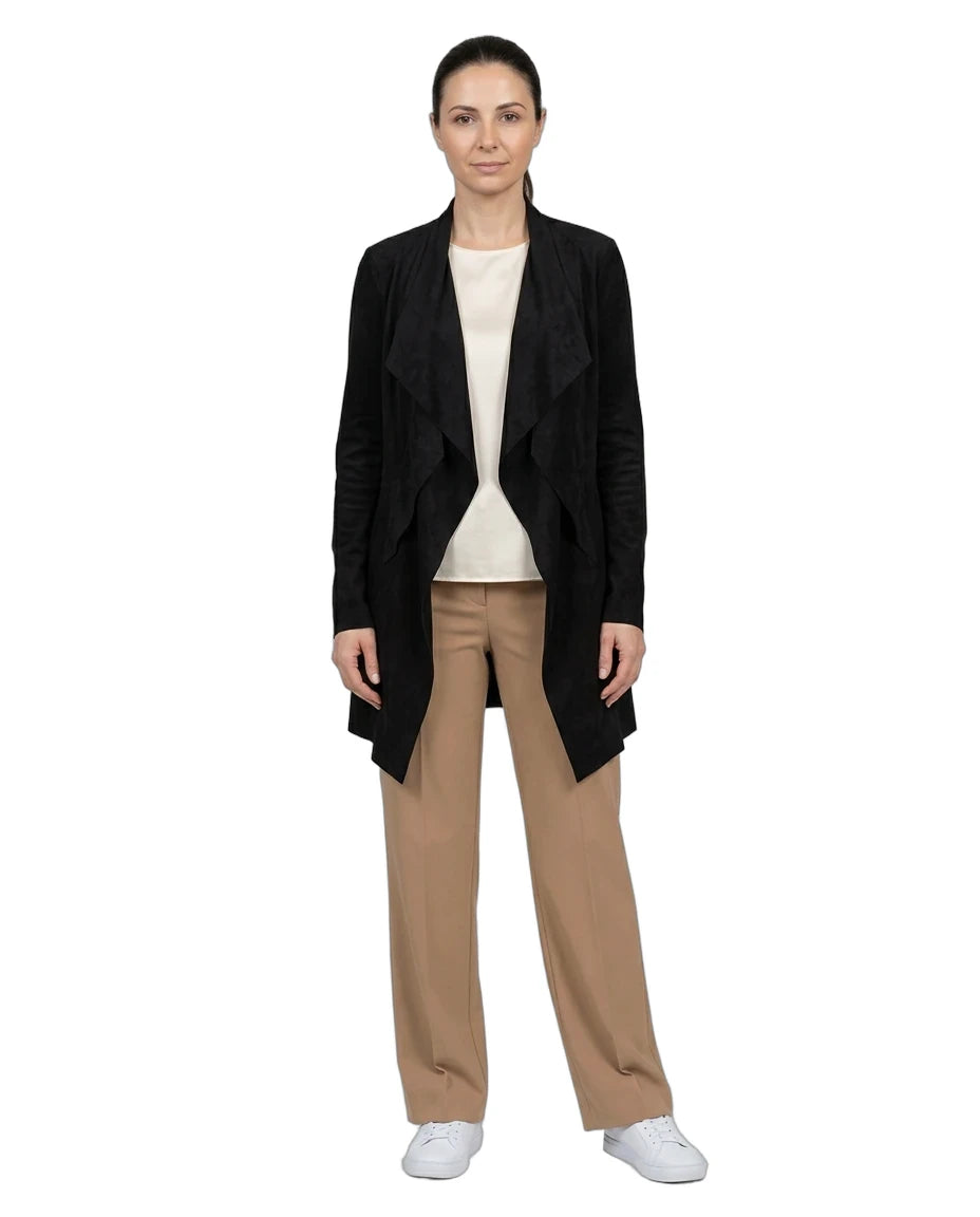 A woman modeling a black open-front draped cardigan over a cream top and beige wide-leg trousers, paired with white sneakers, against a plain white background.