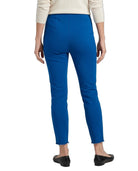 A person shown from the back wearing bright royal blue cropped pants, a cream long-sleeve top, and black flats against a plain white studio background.