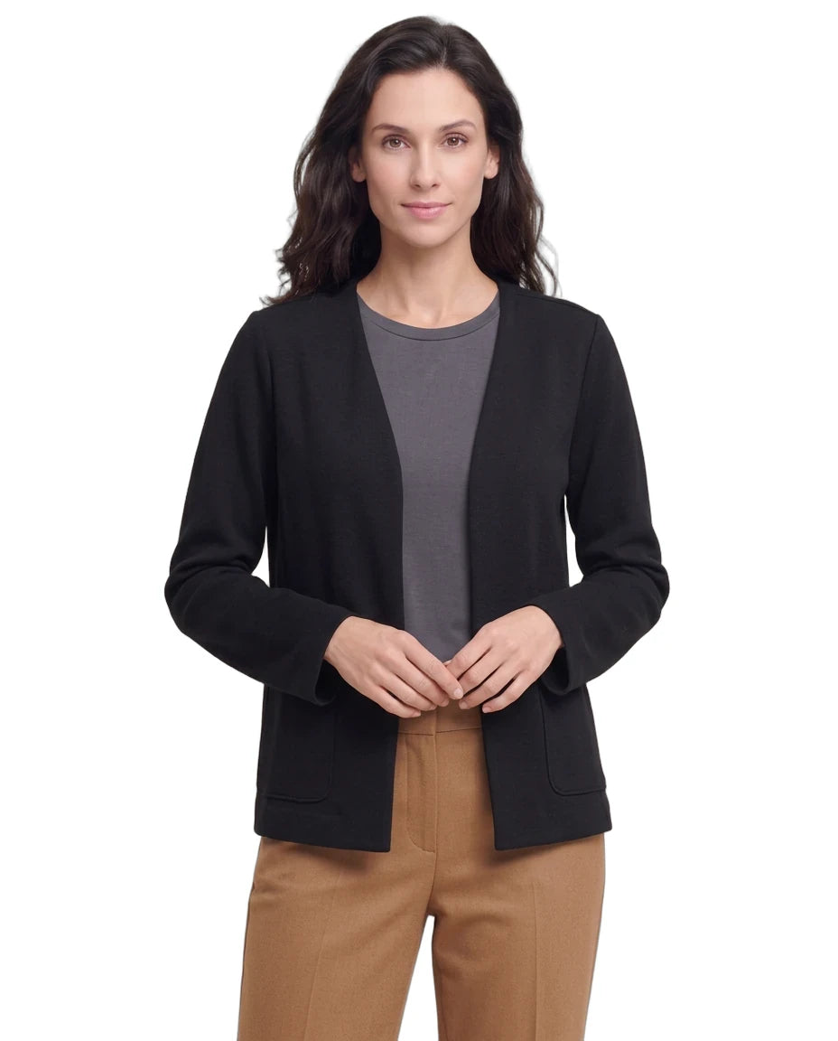 A woman modeling a black open-front cardigan over a dark gray crewneck top and tan pants, photographed against a plain white studio background.
