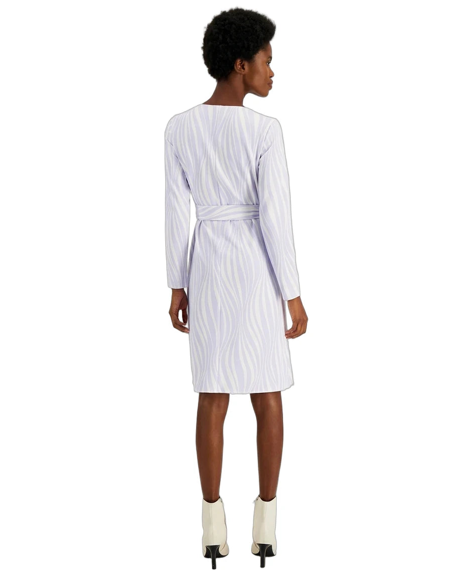 A woman shown from the back wearing a white long-sleeve belted dress with a subtle vertical wavy stripe pattern, paired with white ankle boots, against a plain white background.