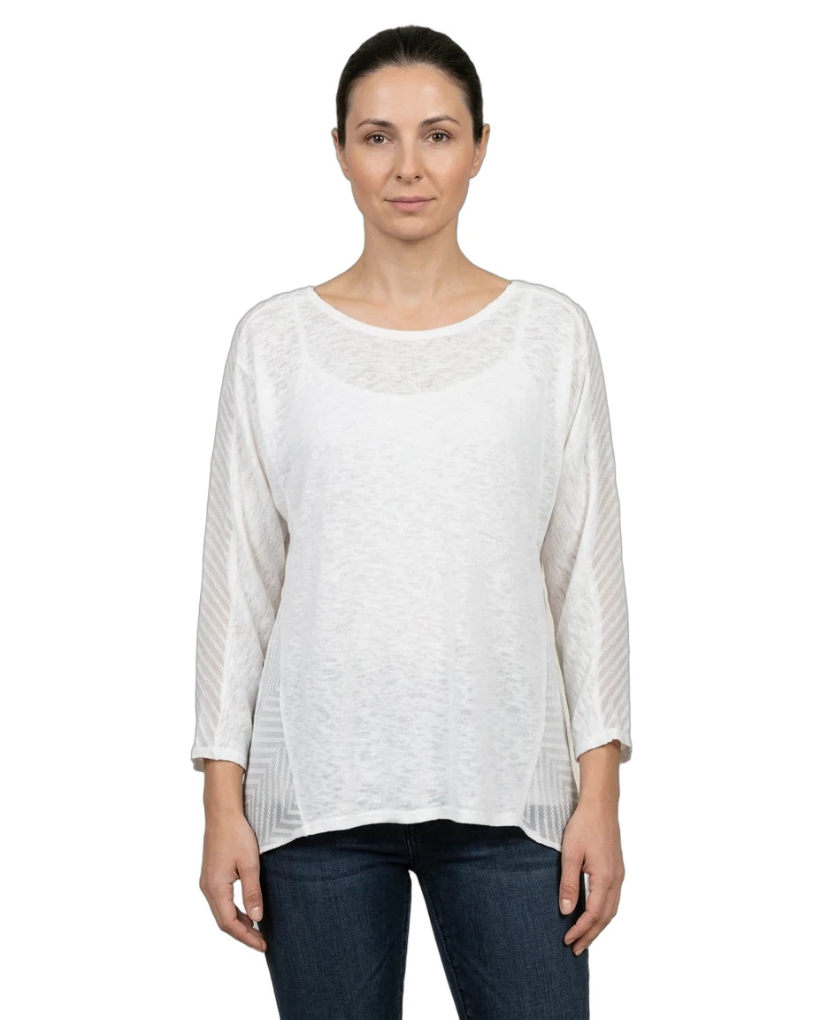 Woman wearing a white long-sleeve top and dark jeans on a white background