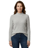 Woman wearing a gray sweater and blue jeans on a white background
