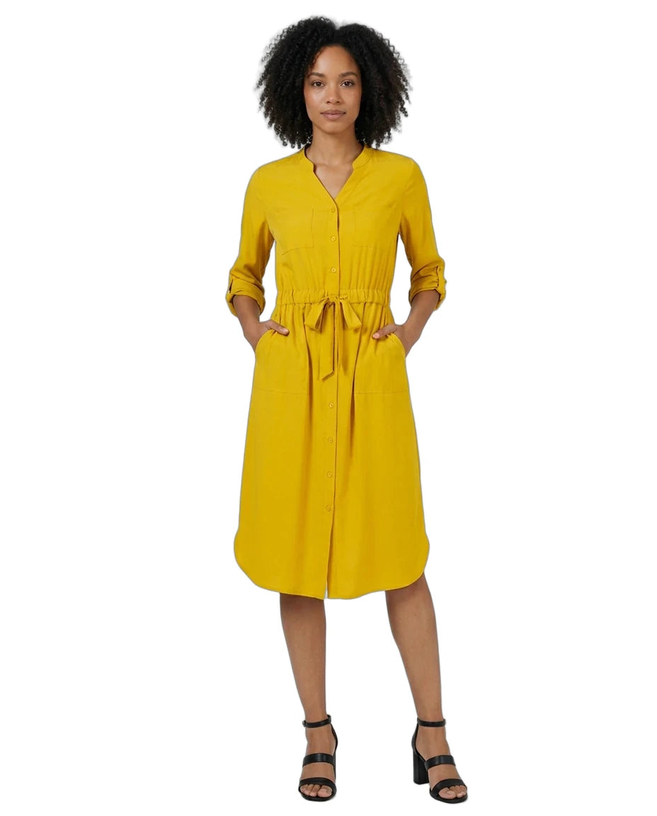A woman modeling a mustard yellow midi shirt dress with three-quarter sleeves, a button-up front, side pockets, and a self-tie waist belt, paired with black strappy heels against a plain white background.