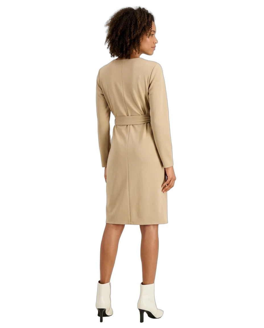 A woman shown from the back wearing a beige long-sleeve knee-length dress with a matching waist tie, paired with white ankle boots, against a plain white background.
