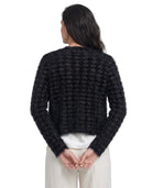 Person wearing a black textured sweater on a white background