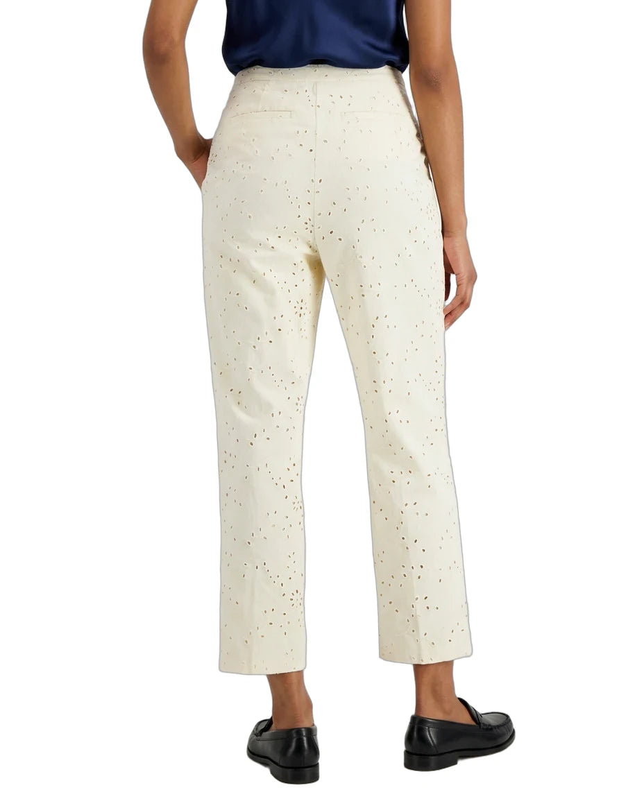 A person shown from the back wearing cream-colored cropped trousers with a subtle speckled pattern, paired with a navy top and black loafers, against a plain white background.