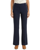 A model wearing a pair of navy blue high-waisted, straight-leg pants with a cream top and brown shoes, shown from the waist down on a white background.
