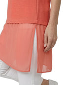 Coral layered dress with sheer overlay on a white background