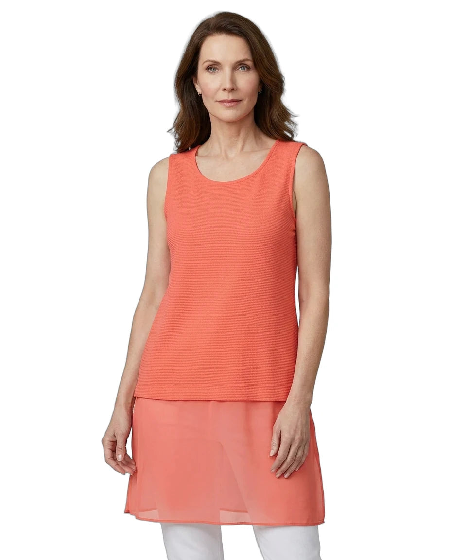 Woman wearing a coral sleeveless top with a white background