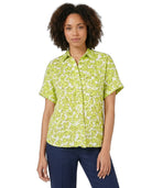 Woman wearing a green patterned shirt on a white background