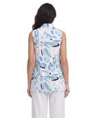 Woman wearing a sleeveless top with abstract blue and black design on a white background