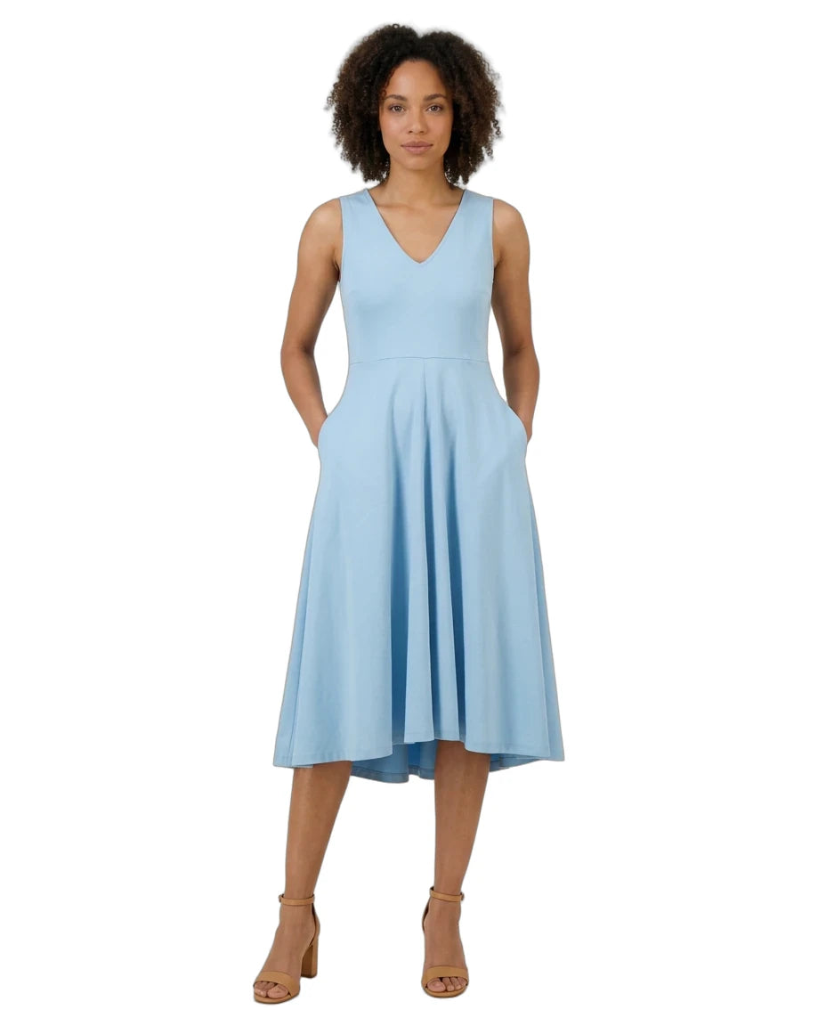 A woman modeling a sleeveless light blue midi dress with a V-neckline, side pockets, and a flared skirt, paired with tan heeled sandals against a plain white background.