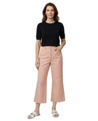 A woman modeling a black short-sleeve crewneck top and light pink cropped wide-leg pants with white slide sandals, set against a plain white background.